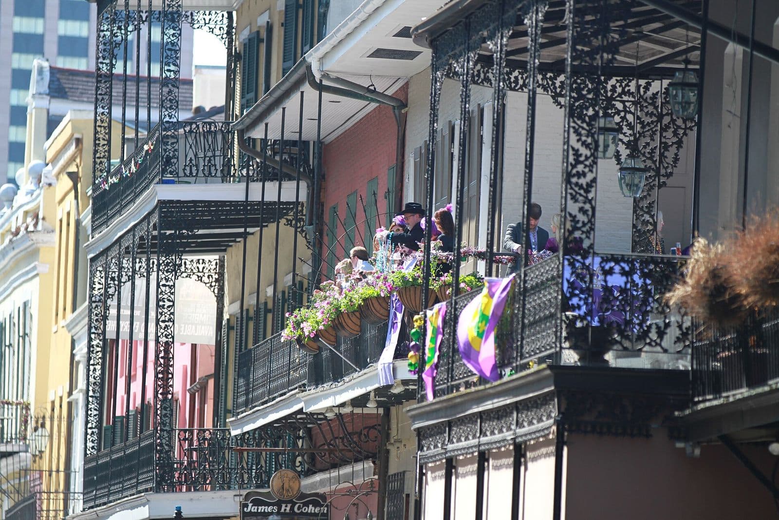 French Quarter balconies with iron lace railings decorated in purple, green and gold during Mardi Gras